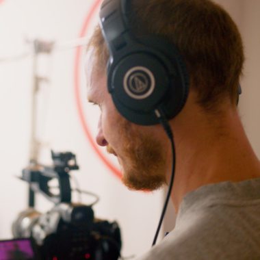 Piotr with headphones on filming on set
