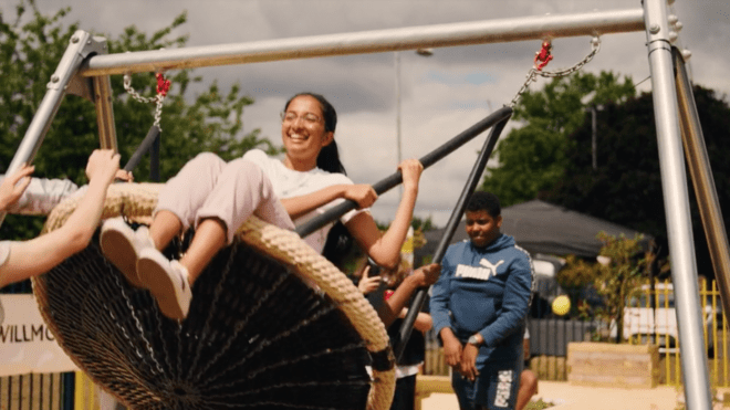 young teen girl on swings with other children surrounding her