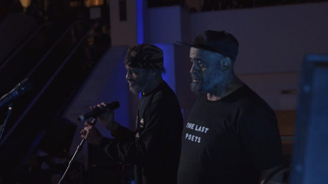 Abiodun Oyewole and Umar Bin Hassan singing on stage.