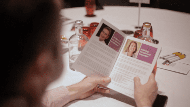 A woman looks through the programme for the 2019 Willmott Dixon Foundation Awards.