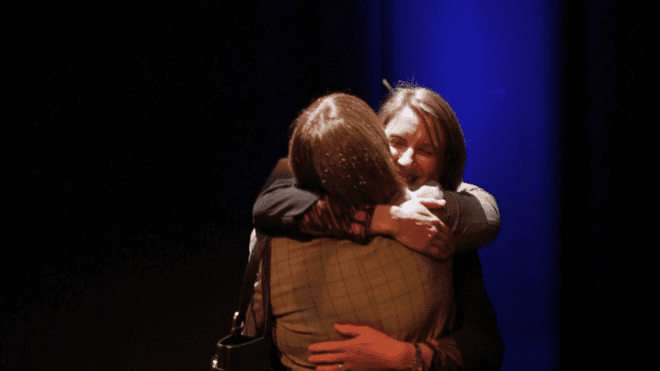 Two women hug at the Willmott Dixon Foundation Awards event.
