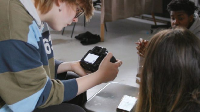 a young person looking down camera screen
